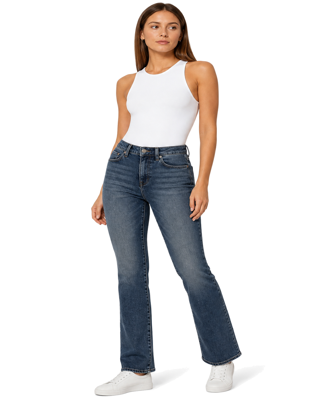 A woman modeling a pair of dark blue straight-leg jeans with a white sleeveless top and white sneakers, standing against a plain white background.